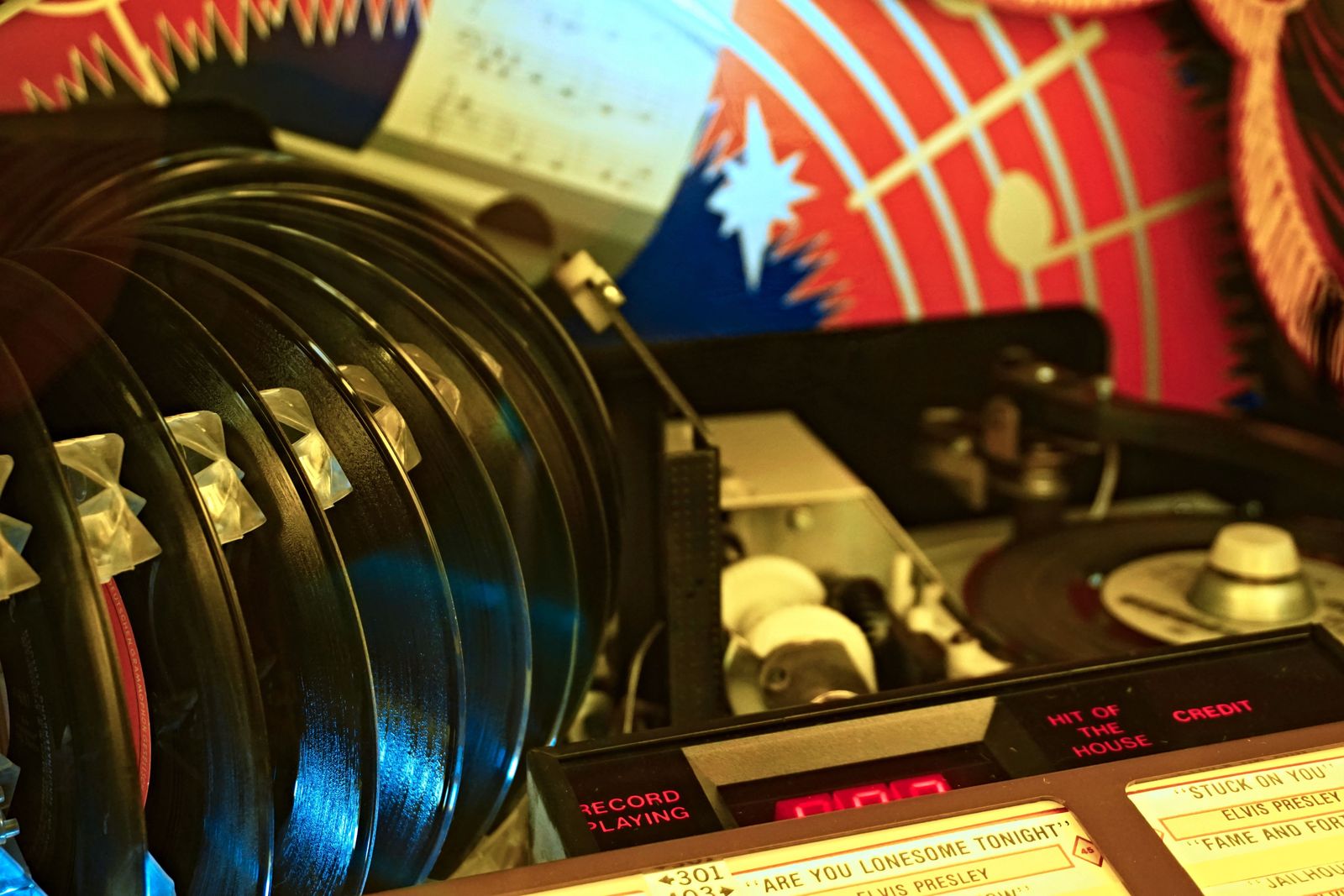 Close-up of a classic jukebox record-selection mechanism with chrome and vinyl records