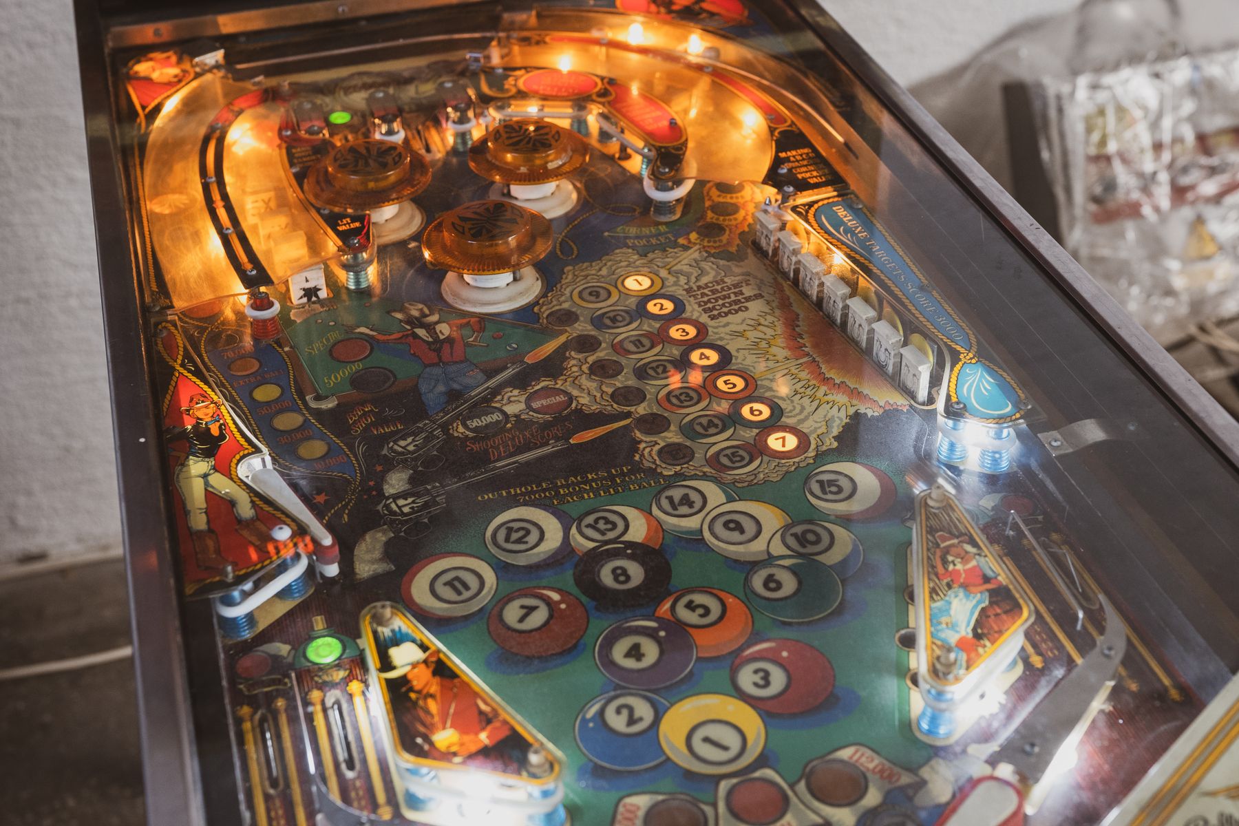 Colorful pinball machine playfield lit up in an arcade